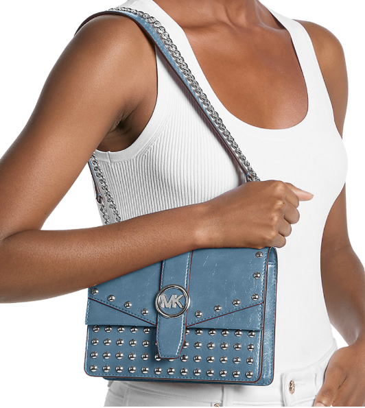 Crossbody Michael Kors Greenwich Studded azul modelo llevando el bolso